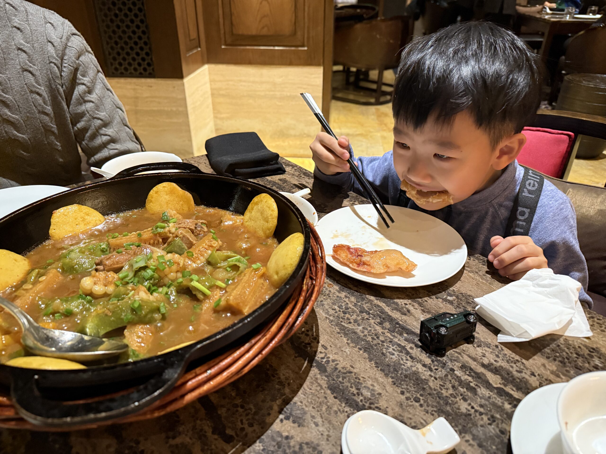 A yummy dish with pork, potatoes, beans, carrots, and corn